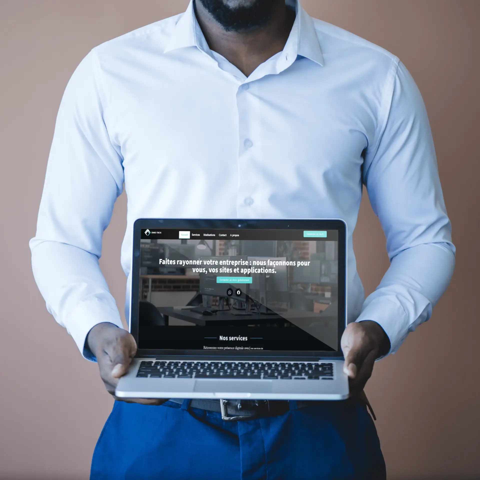 dme-teck | Homme tenant un ordinateur portable affichant le site web dme-teck.